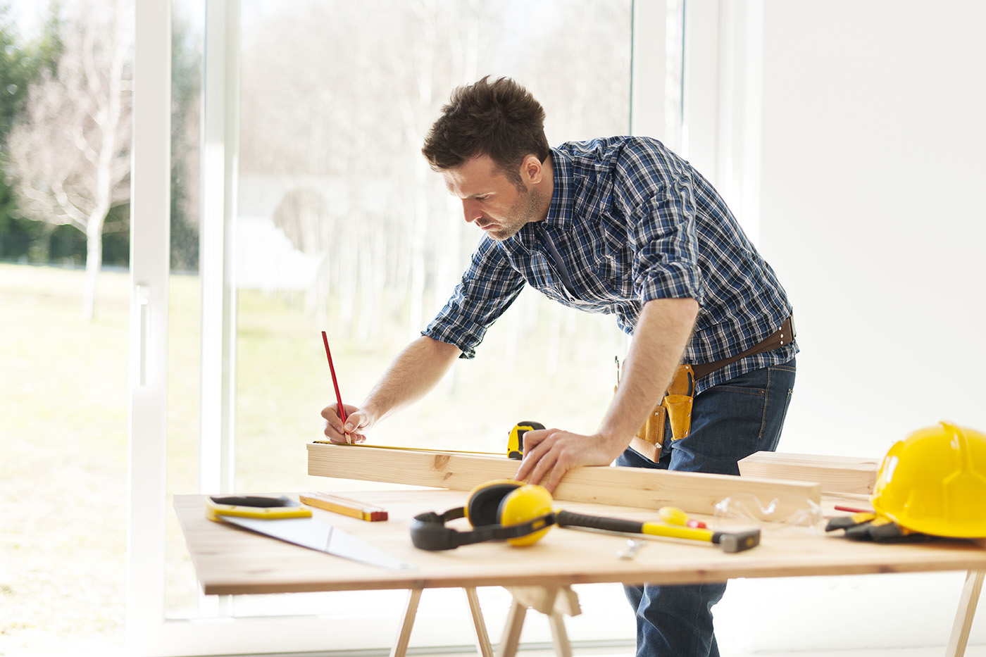 Focus man measuring wooden planks