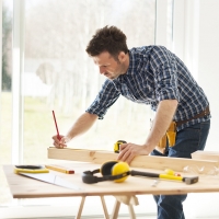 Focus man measuring wooden planks